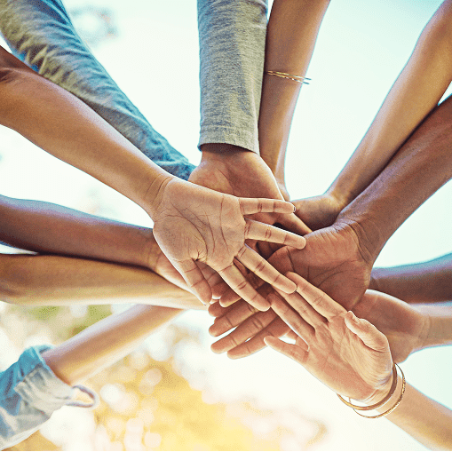 Multiple hands stacked together symbolizing unity and teamwork.